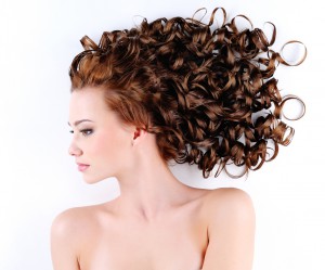 portrait of the beautiful young woman with beauty long ringlets hairs lying on the floor